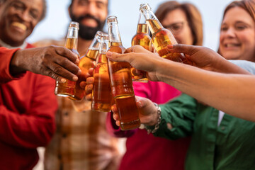 close up of friends toasting with beer in hand.