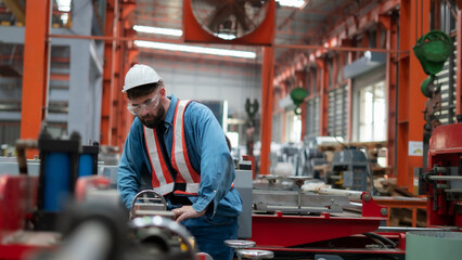 Male worker working with machinery, working at factory warehouse Employees working in industrial...