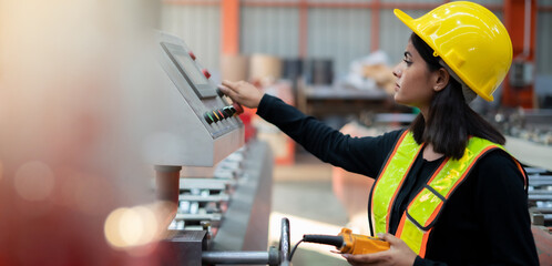 Female worker working with machinery, working at factory warehouse Employees working in industrial...