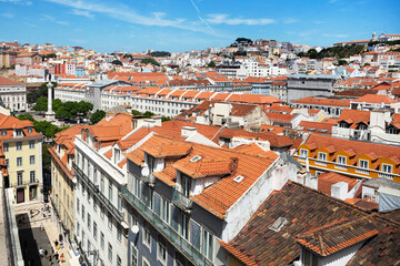 Fototapeta na wymiar View of the street of a beautiful city with bright houses and tiled roofs from the top of the blue sky background during the day. Beautiful city landscape. Lisbon, Portugal.