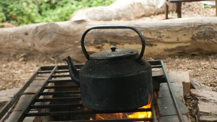 Closeup shot of an old metal teapot on an outdoor grill