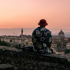 Back view of a male street artist looking at Florence, Italy at sunset