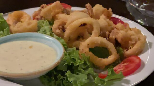 Crispy fried squid calamari served as dinner appetiser in a restaurant