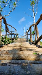Wooden stairs with wooden railings and blue sky on the background
