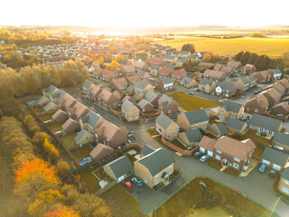 New housing estate seen during late autumn at the edge of an autumnal park. A large attenuation...