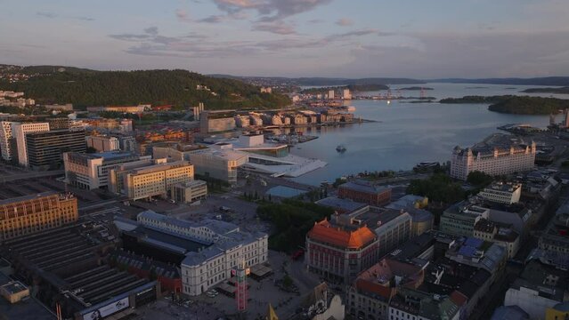 Aerial slide and pan shot of modern urban borough in former docks on waterfront. Panoramic view of cove at golden hour. Oslo, Norway