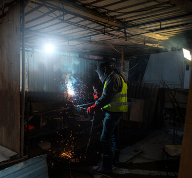 Welder working at dark construction site