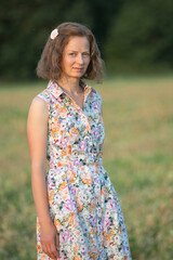 Fototapeta na wymiar Portrait of a young beautiful girl in a light dress on a summer field.