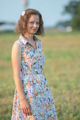 Portrait of a young beautiful girl in a light dress on a summer field.
