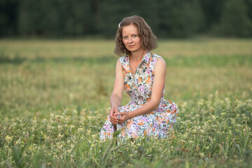 Portrait of a young beautiful girl in a light dress on a summer field.