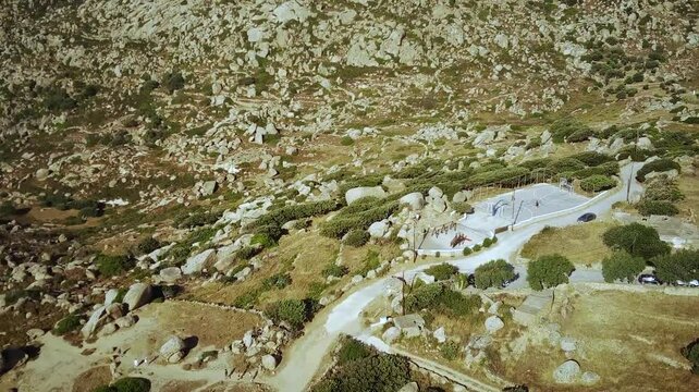 High drone footage of the public playground and granite boulders in Volax village in Tinos, Greece