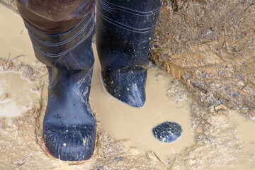 Sturdy black work rubber boots perform perfectly in demanding use in a muddy trench - reliable...