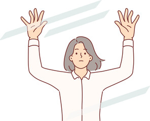 Sad woman raises hands standing behind transparent glass, symbolizing barrier to success