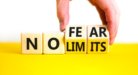 No fear and limits symbol. Concept words No fear No limits on wooden block. Beautiful yellow table white background. Businessman hand. Business motivational no fear and limits concept. Copy space.