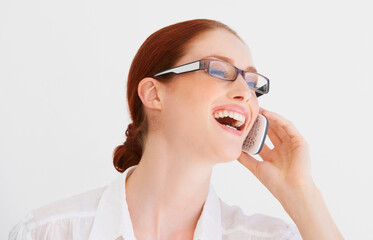 Laugh, phone call and woman with glasses in a studio for discussion with positive attitude. Happy, technology and young female model on mobile conversation with cellphone isolated by white background