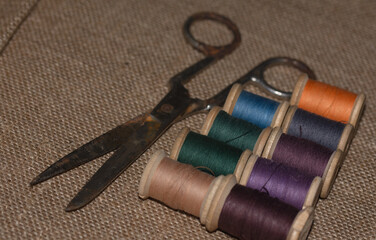vintage old threads on wooden spools and rusty scissors.
