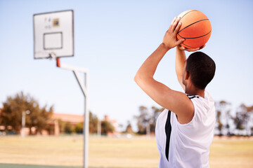 Man, player and shot on basketball outdoor court for point jump athlete, game challenge in summer. Male person, arm and sport score at hoop for exercise fun or fitness training action, active in park