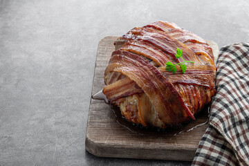 Italian bacon wrapped meatloaf on wooden board