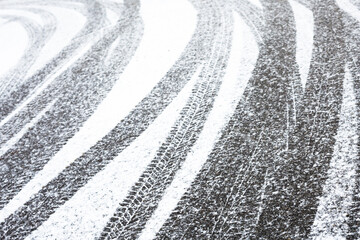 Wheel tracks on the road covered with snow