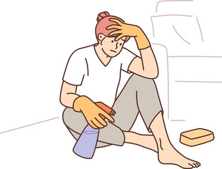 Woman housewife cleaning up trying to wipe stain from carpet and sits on floor with desperate look