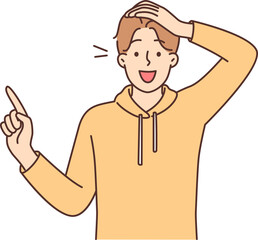 Amazed man points finger to side and opens mouth in surprise at profitable promotional offer