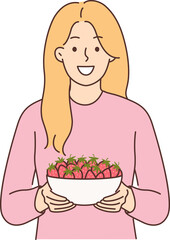 Woman holds plate of strawberries and smiles, offers to try fresh berries and farm fruits