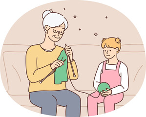 Little girl child knitting together with grandmother