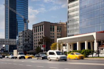 Cars quickly rush along the road against the backdrop of skyscrapers in a prestigious area of the...