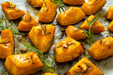 Roasted pumpkin with rosemary and garlic on wooden table