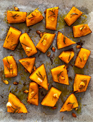 Roasted pumpkin with rosemary and garlic on wooden table
