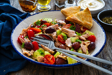 Tuna greek salad on wooden table
