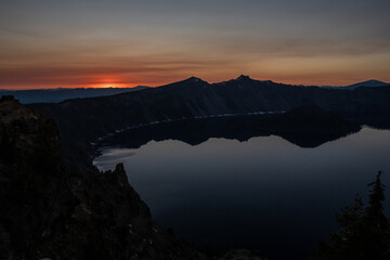 Dark Shadows Of Surrounding Cliffs Reflect In Crater Lake