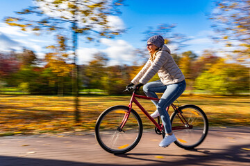 Motion Blur.  Woman riding bicycle in city park