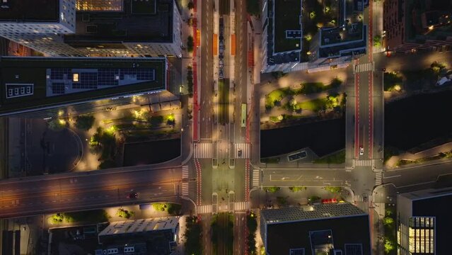 Tracking of city bus passing on wide street in modern residential urban borough. Evening birds eye shot of buildings and roads in city. Oslo, Norway