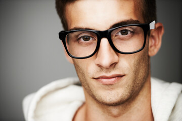 Closeup, portrait and man with glasses in studio for eye care mock up on gray background in Spain....