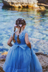 Fototapeta na wymiar child in a blue dress on the beach in cyprus 