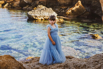 child in a blue dress on the beach in cyprus 