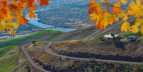 View of Lewiston, Idaho and Clarkston, Wa from the Lewiston Hill overlook framed by fall maple leaves © James Cottingham