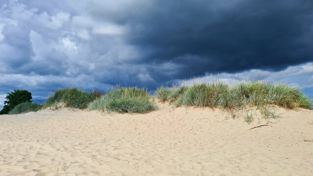 Dark thick rain clouds covered the entire sky against the backdrop of sand dunes