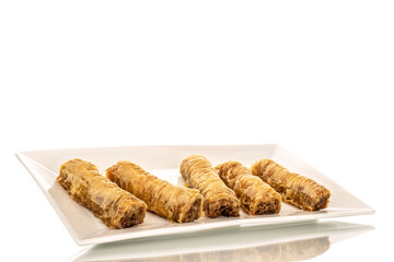 Several pieces of sweet baklava on a white ceramic plate, close-up, isolated on white background.