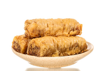 Three pieces of sweet baklava on a ceramic plate, close-up, isolated on white background.