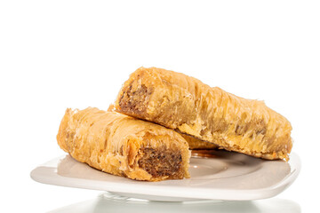 Three pieces of sweet baklava on a ceramic plate, close-up, isolated on white background.