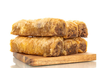Several pieces of sweet baklava on a wooden kitchen board, macro, isolated on white background.