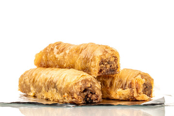 Three pieces of sweet baklava on foil, macro, isolated on white background.