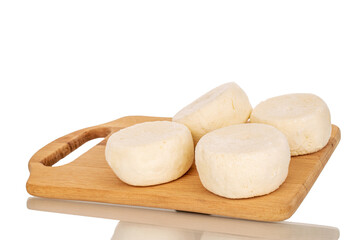 Several frozen semi-finished cheesecakes on a wooden kitchen board, macro, isolated on white background.