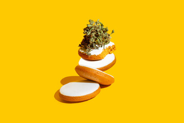 Delicious gingerbread cookies stuffed with cannabis. Creative concept on yellow background - 676921567