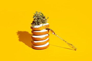 Delicious gingerbread cookies stuffed with cannabis. Creative concept on yellow background - 676921569
