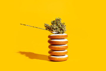 Delicious gingerbread cookies stuffed with cannabis. Creative concept on yellow background - 676921581