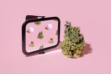 A funny composition of a cannabis bud reflected in a mirror on a pastel background. - 676921582