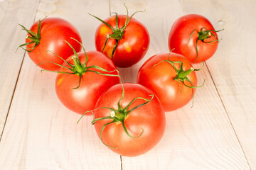 Several ripe red tomatoes on a wooden table, macro